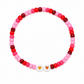 Double Tap beaded bracelet with red, hot pink, soft pink, and burgundy beads and two white beads with golden hearts
